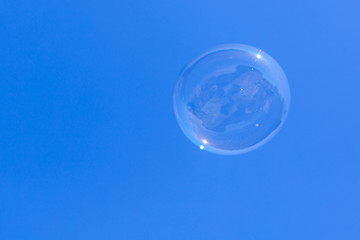 Soap bubbles in flight against the blue sky