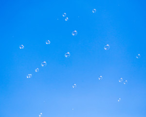 Soap bubbles in flight against the blue sky