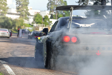 Drift cars standing at the start line, waiting for race to begin. Rally car warming up the tires, blue smoke all around     © lainen