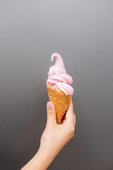 Pink ice cream in the hand.