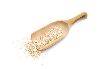Wooden spoon or scoop with healthy quinoa seeds isolated on white background