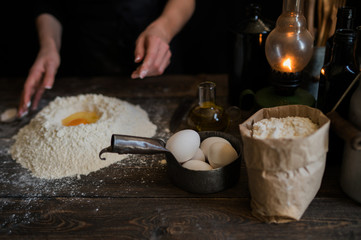 Hands working with dough preparation recipe bread, pizza or pie making ingridients, food flat lay on kitchen table background. Butter, milk, yeast, flour, eggs, pastry or bakery cooking.