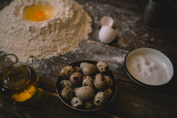 Food, cooking and baking concept. Dough on a rustic wooden background with dusting of flour. Raw dough for pizza, ingredients and kitchen accessories on dark wooden background. Rural kitchen.