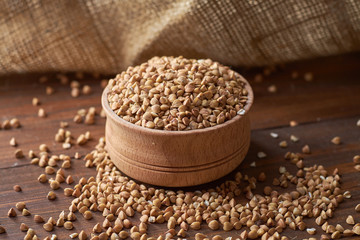 Buckwheat in a bowl on a wooden table with a bag in the background