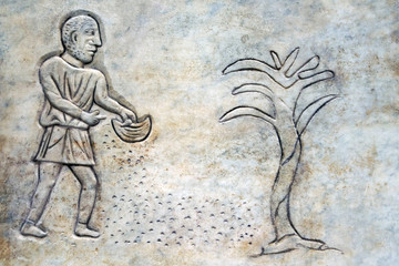 Bas-relief of an ancient Roman farmer throwing seeds on the ground. In the the public Baths of Diocletian in Rome, Italy. It was built from 298 to 306