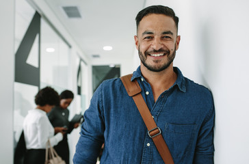 Man in casuals standing at office hallway