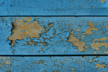 Texture/background - blue wooden board with chipping paint and scratches.