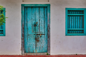 Old house wall with wooden door and window.
