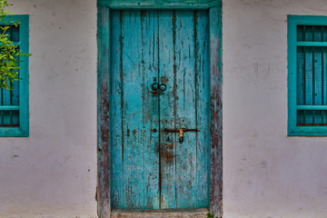 Fototapeta na wymiar Old vintage wall with wooden window and worn wooden door.