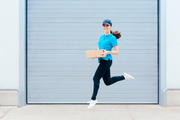 Fototapeta na wymiar Female Delivery Worker Jumping in front of a Storage Warehouse