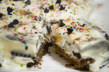 Pastel de galletas y crema con chispas de chocolate y granas de colores 