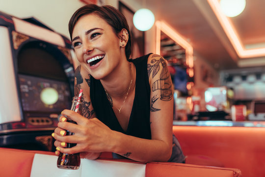 Woman at a restaurant holding a soft drink