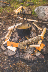 hike a fire, a kettle on a tripod over firewood, preparation of a dinner