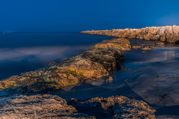 rocks in the sea with silky water at sunrise