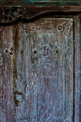 Close up ornamental wood carving door decoration. Carving art. Gray and shabby entrance door with traditional asian style design. Vintage background and wallpaper. Exquisite wood carving technology.