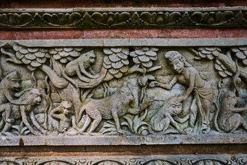 Detail of relief  wall with stone carving in Bali,Indonesia. Temple with traditional stone carving indonesia. Relief sculpture on the wall of a Buddhist temple. Ancient stone carving covered with moss