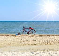 old red bicycle standing by the sea