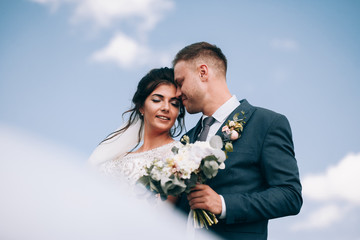 Newlyweds on the background of blue sky.Wedding photo