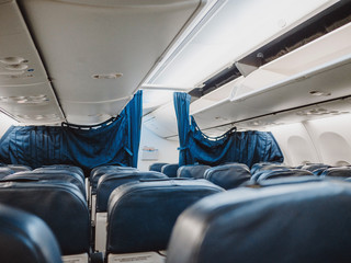 Obraz premium View from passenger place. Empty aircraft cabin during flight. Blue leather interior of plane salon.