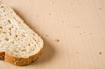 Slice of white bread on wooden cutting board.