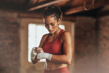 Female boxer wearing strap on wrist - obrazy, fototapety, plakaty