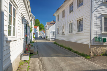 A street full of white wooden houses in Flekkefjord