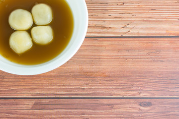  Black Sesame Dumplings in Ginger Tea or Bualoy, thai dessert street food  in white bowl on wooden table background