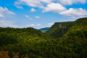 Obraz premium Autumn mountain landscape. Beautiful colorful autumn landscape with forest in toned vintage style with warm color. Amazing view at sunny autumn day with forest and valley and bright blue sky.