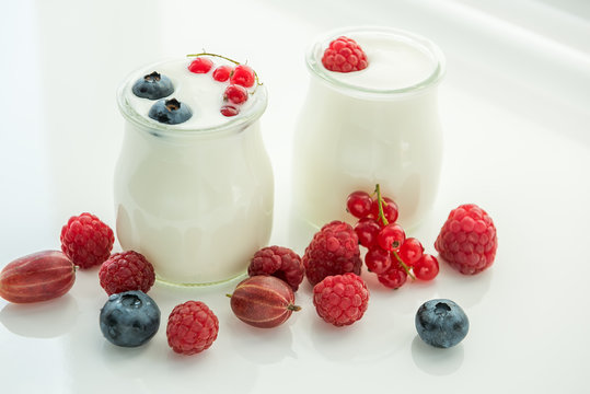 Yogurt and various berries on a light background. A useful delicious breakfast
