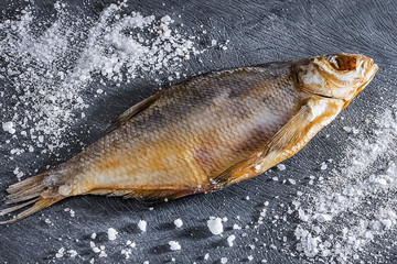 A dry salted fish on a gray  background.