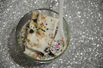 
Porción de pastel de cumpleaños con fondo de plata brillante, ropa desde arriba. 