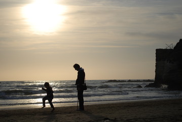 Famiglia che gioca sulla spiaggia - silouette