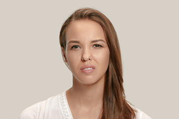 Annoyed irritated young feeling frustrated with something against white studio. Human facial...