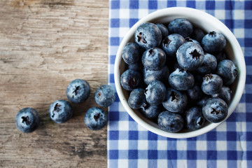 Blueberries in a white bowl on a wooden table