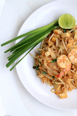 Thai style noodles, Pad Thai, stir-fried rice noodles with shrimp serve with vegetable in white plate on white background. The one of Thailand's national main dish. the popular food in Thailand.