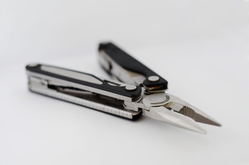 Closed metal pocket knife and pliers, multitool isolated on plain white background