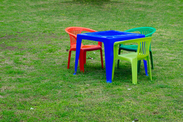 Color mini plastic chairs and table on the lawn