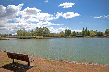 青い空白い雲と緑に溢れ、川が流れる湖のほとりにある落ち着いた雰囲気のベンチまで散歩するサマータイム