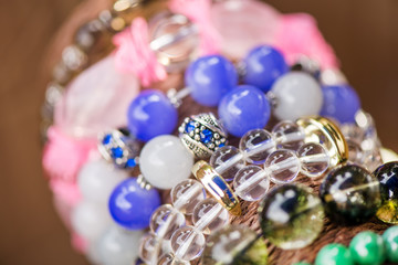 Gemstone bracelets and necklaces in a row. Jewelry made of heliotrope stone, swarovski crystals, moonstone and sugilite blue stone. Healing, powerful crystal energy. Esoteric and colorful background