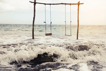 dangerous wooden swing over the sea.