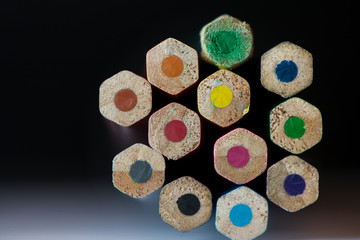 Pile of sharp coloured drawing pencils on table. Rainbow colors  red, yellow, blue, green, purple. Concept of art, crafts and kids having fun
