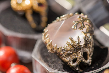 Macro shot of silver engagement ring in gift box on colorful, sparkling background. Rose Quartz Crystal is rose pink colored quartz that aids all types of relationships. powerful healing crystal