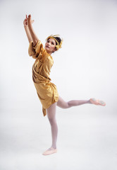 The beauty lady is wearing glod dress ,wear ballet shoes,posing basic ballet pattern