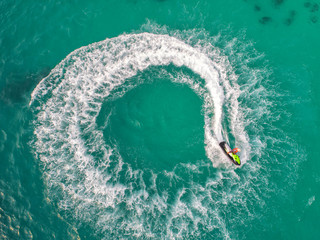 People are playing jet ski at sea during the holidays. Aerial view and top view.