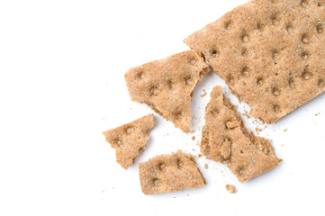 Crunchy crispbread with crumbs on white background.