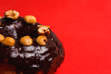 Chocolate donut with hazelnutred on a red background