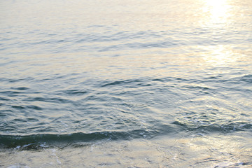 The sea with waves hit the sandy beach in the morning, with copy space text