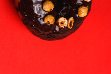 Chocolate donut with hazelnutred on a red background