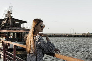 The girl admire the seascape. River harbor.