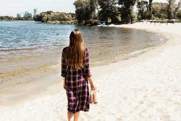 Pretty girl with long hair walking on the sea beach. Relaxation. Seascape.